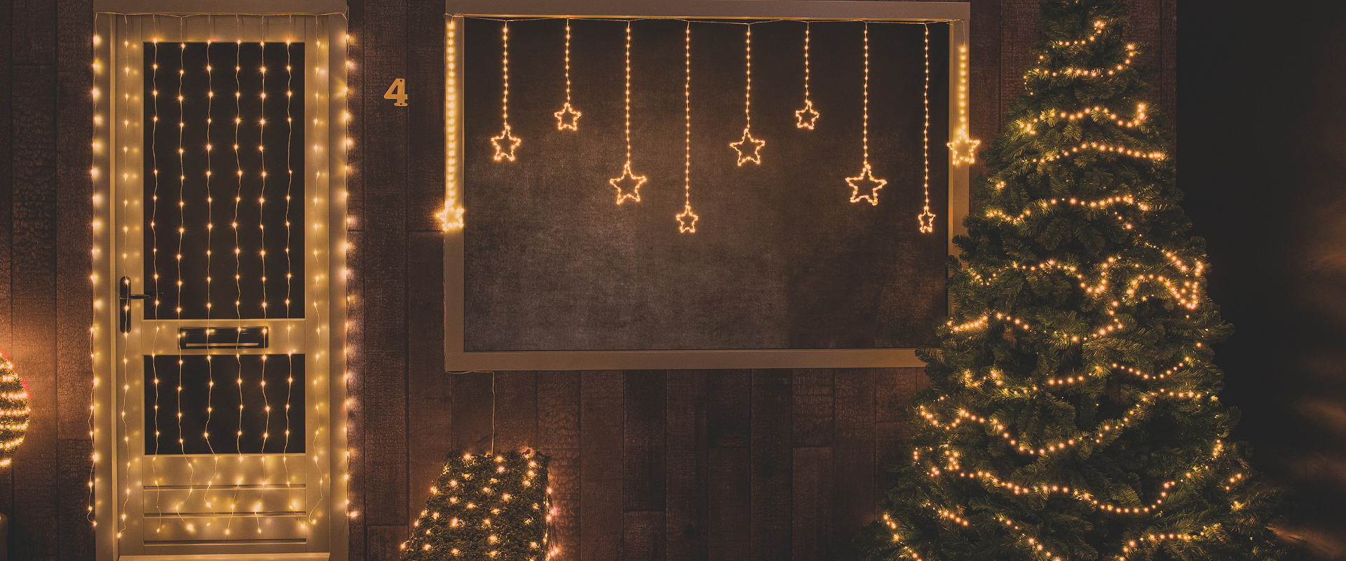 Sfeervolle kerstverlichting in de showroom van Anna’s Collection, inclusief gordijnverlichting en lichtsnoeren.